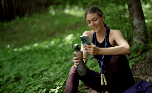 Person using mobile device in forest